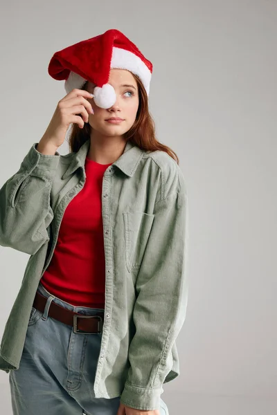 Дівчина в різдвяній шапці з помпоном і в моделі джинсів червоної футболки Новий рік — стокове фото
