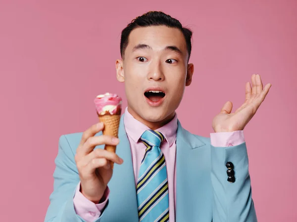 感情的な男で青いスーツのアイスクリームピンクの背景クロップドビュー — ストック写真