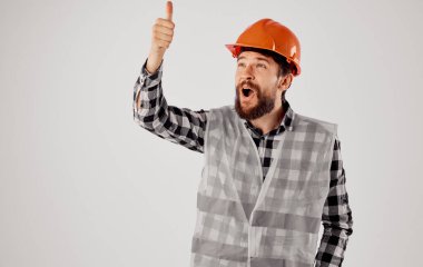 Üniformalı adam turuncu kask inşaat işi yapıyor.