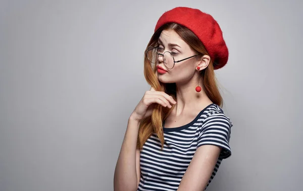 Vrouw met rode hoed en gestreepte t-shirt bril op gezicht portret — Stockfoto
