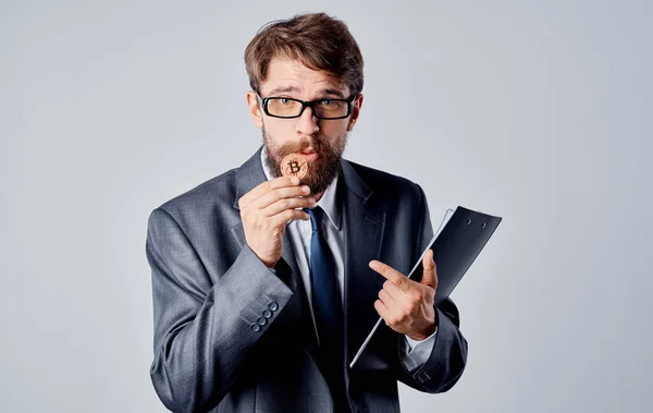 Geschäftsmann mit Münze in der Hand auf grauem Hintergrund — Stockfoto