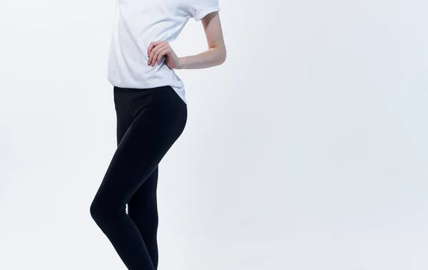 Fitnessport donna in leggings tiene la mano sullo sfondo luce vita — Foto Stock