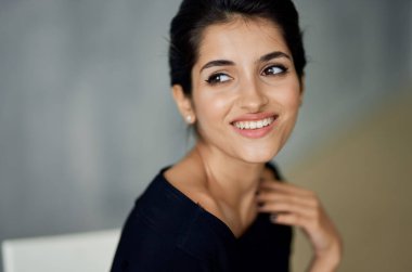 Güzel Lydia. Siyah bir elbise içinde akşam makyajıyla bir sandalyede oturuyor.