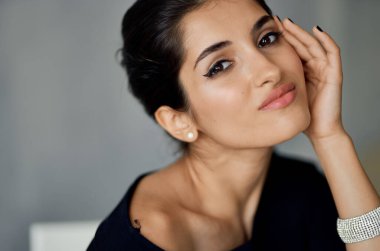 Gri arka planda bileziği olan seksi esmer kadın portresi.