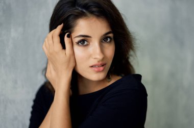 Küpeli güzel romantik bir kadının portresi ve gece makyajı modeli gri arka plan.