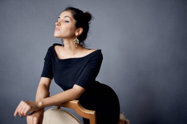 Sandalyedeki romantik kadın içeride seksi görünüm küpeleri makyaj