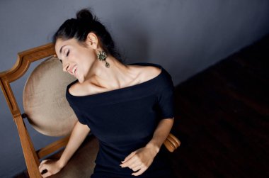 Sandalyedeki romantik kadın içeride seksi görünüm küpeleri makyaj