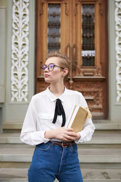 Studentka v brýlích a džínách u dveří na ulici Institut pedagogické fakulty — Stock fotografie