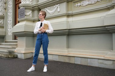 Elinde kitap gözlüğü olan sevimli bir kız öğrenci. Eski moda eğitim enstitüsü.