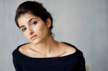 Çekici kadın portresi. Beyaz sandalyede akşam elbisesi. Kapalı kapılar ardında.