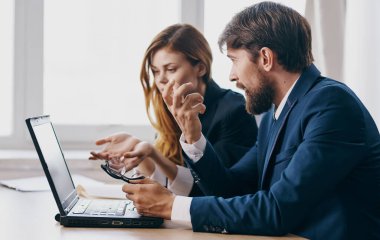 Takım elbiseli iş arkadaşları dizüstü bilgisayarlı ofis yöneticileri ekibinde çalışıyor.