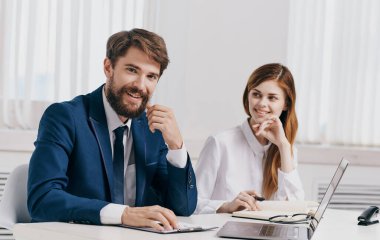 İşadamı ve çalışanı laptopta iş belgeleriyle ofiste.