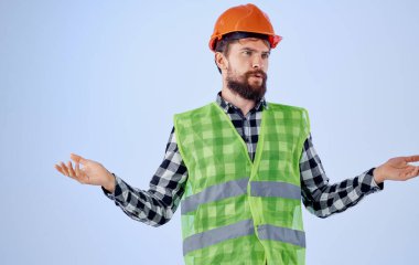 Elinde turuncu başlık ve yansıtıcı yelek olan bina mavi arkaplan kopyalama alanı