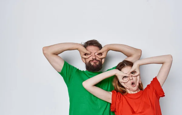 Эмоциональный мужчина и женщина в красочных футболках студия семейного образа жизни — стоковое фото