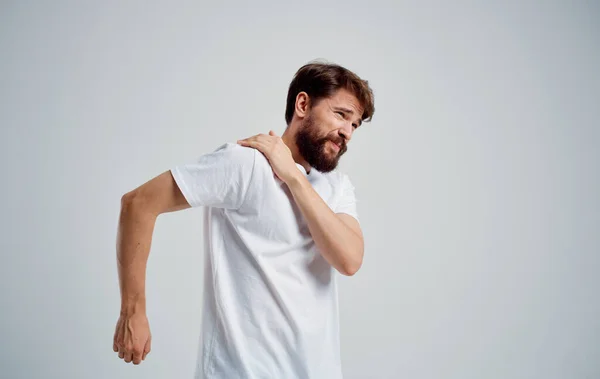 Hombre tiene dolor en el hombro y blanco camiseta dislocación problemas de salud —  Fotos de Stock