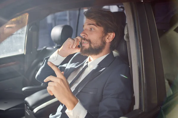 Hombre de negocios en un traje hablando por teléfono en un modelo de financiación de automóviles — Foto de Stock