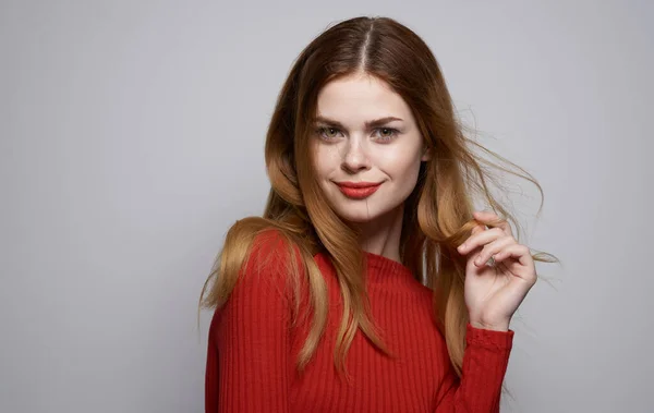 Schöne Frau in rotem Pullover hell Make-up grau Hintergrund abgeschnitten Ansicht — Stockfoto