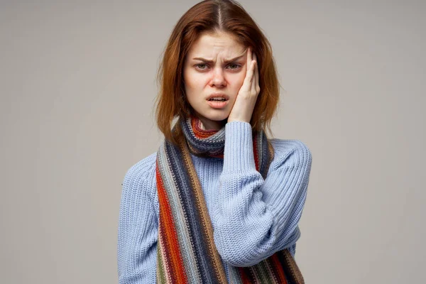 woman sick on gray background and health problems throat runny nose scarf