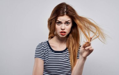 Çizgili tişörtlü, saç stili gülüşlü şık bir kadın.