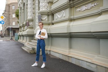 Elinde kitap gözlüğü olan sevimli bir kız öğrenci. Eski moda eğitim enstitüsü.