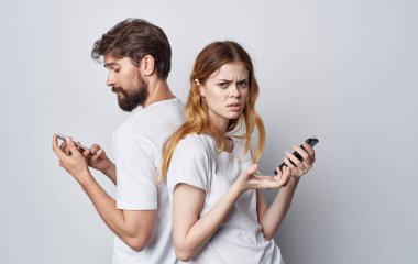 Genç bir çift, telefon çevresi yaşam tarzı arkadaşlığı olan beyaz tişörtler.