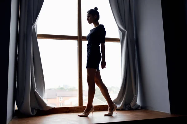 Las mujeres en ancho alféizar de ventana de longitud completa y cortinas modelo vestido de noche — Foto de Stock