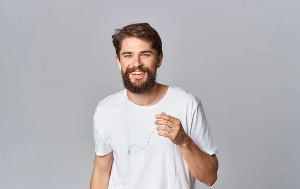 handsome guy in headphones on gray background white t-shirt emotions model