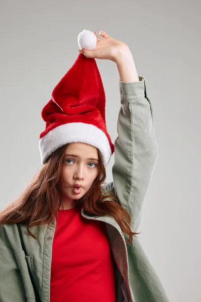 Fille dans un chapeau avec un pompon levé sa main sur un fond gris vue recadrée — Photo