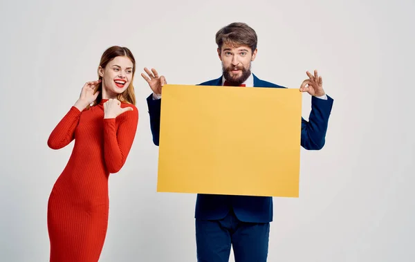 Femme heureuse et homme avec feuille de papier jaune sur fond clair Affiche maquette — Photo