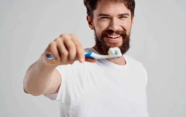 Muž se zubním kartáčkem v ruce ústní dutiny péče ranní procedury sněhobílý úsměv — Stock fotografie