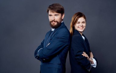 Takım elbiseli başarılı insanlar, gri arka plan finans sektöründe birbirlerine sırtlarını dönerek ayakta duruyorlar.