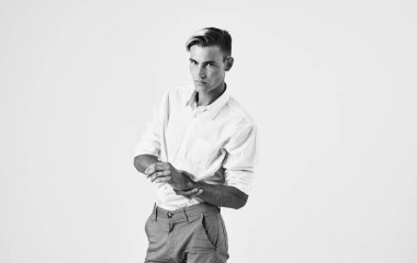 Modaya uygun giyinmiş bir adam ellerini arka planda açık bir şekilde hareket ettiriyor.