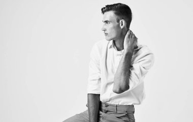 Siyah ve beyaz bir fotoğraf. Yakışıklı bir adamın elleri açık bir arka planda hareket ederken çekilmiş.