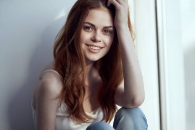 Pencere kenarında oturan güzel bir kadın Gülümseme büyüsü sabah