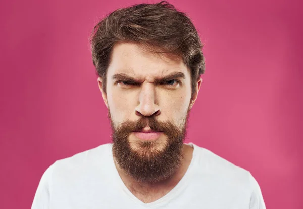 핑크 색 배경에 털 많은 턱수염을 가진 남자 티셔츠를 입은 남자 — 스톡 사진