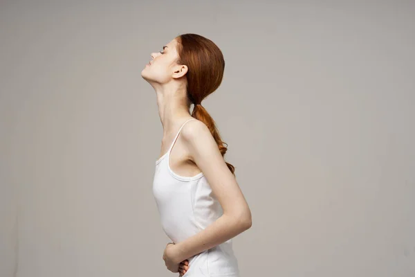 Žena v bílém tričku drží její břicho zdravotní problémy menstruace gynekologie — Stock fotografie