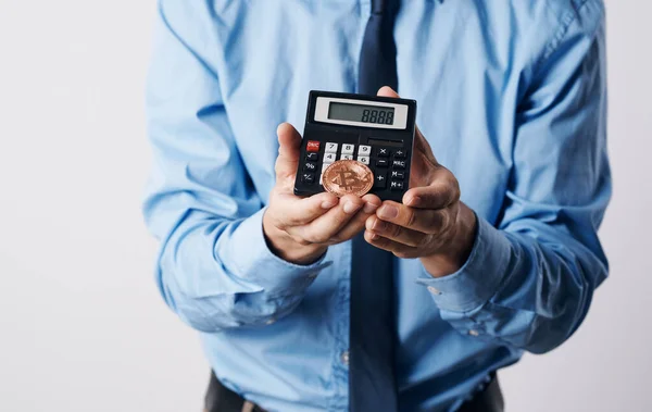 Um homem segura em suas mãos uma tecnologia financeira de calculadora de aumento de preço de criptomoeda Bitcoin — Fotografia de Stock