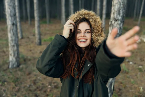 Жінка в капюшоні витягнула руку подорожувати крізь ліс — стокове фото