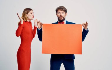 Takım elbiseli ve papyonlu duygusal bir adam ellerinde bir model ve genç bir kadınla.