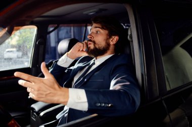 Takım elbiseli bir iş adamı araba finans modelinde telefonla konuşuyor.