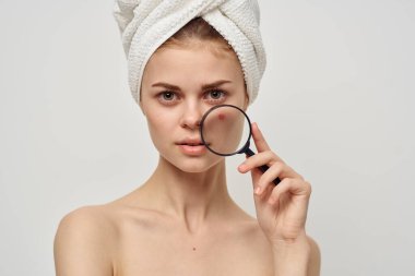 Yüzünde büyüteç olan güzel bir kadın sivilceli bir cilt bakımına gitmiş.