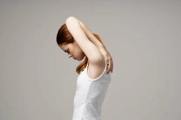 Donna dai capelli rossi in t-shirt bianca che si tocca con le mani su sfondo grigio vista ritagliata — Foto Stock