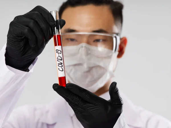 Asiatico uomo medico maschera sangue test ricerca nero guanti — Foto Stock