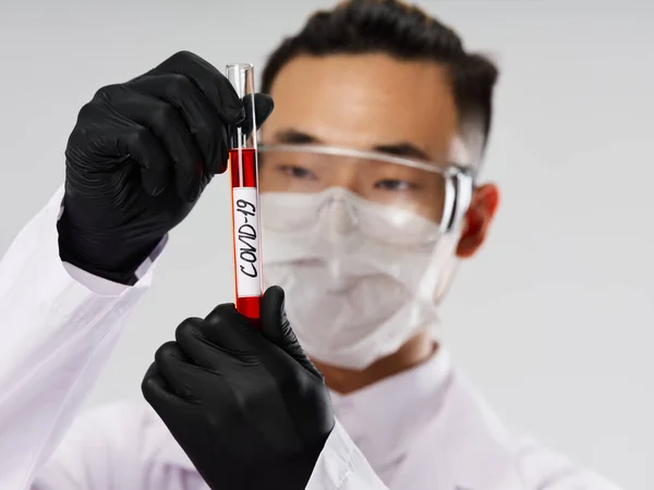 Man laboratorieassistent medicinsk mask blodprov diagnostik svarta handskar — Stockfoto
