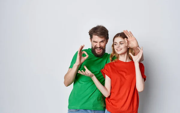 Эмоциональный мужчина и женщина в красочных футболках студия семейного образа жизни — стоковое фото