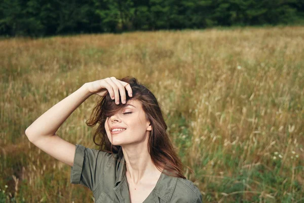 Mulher no campo olhos fechados sorriso apreciando a natureza — Fotografia de Stock