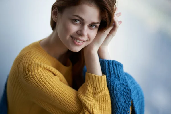 Vacker kvinna i gul tröja leende attraktiv look hem interiör — Stockfoto