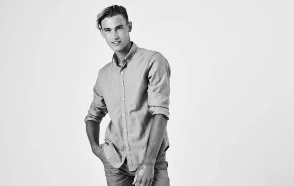 Jovem atraente em camisa e calças em um fundo claro retrato de fotografia em preto e branco — Fotografia de Stock