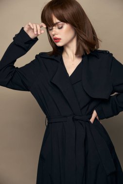 Komik model siyah ceket büyüleyici gülümseme bej arka planda eğleniyor 