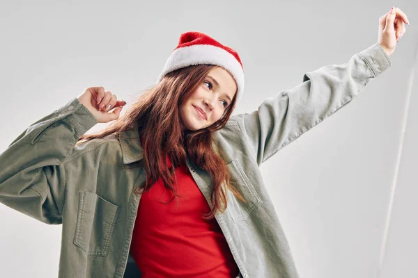 Belle petite fille en chapeaux de vacances geste avec ses mains amusant danse fête de Noël — Photo